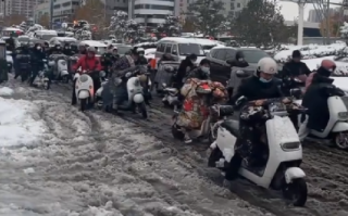 河南市民骑电动车在雪地里艰难前行：调侃12月11日成为了郑州全民迟到日 ！
