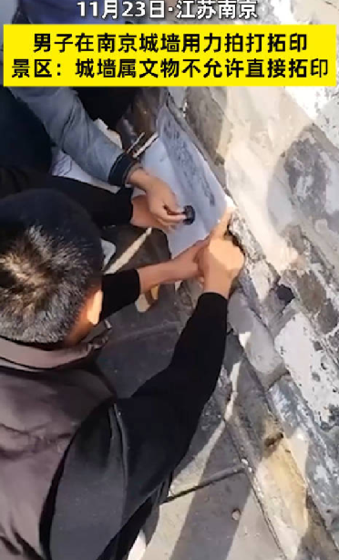 两男子拍打拓印南京古城墙字迹 ！景区回应：城墙属于文物，不允许直接拓印 ！-第1张图片